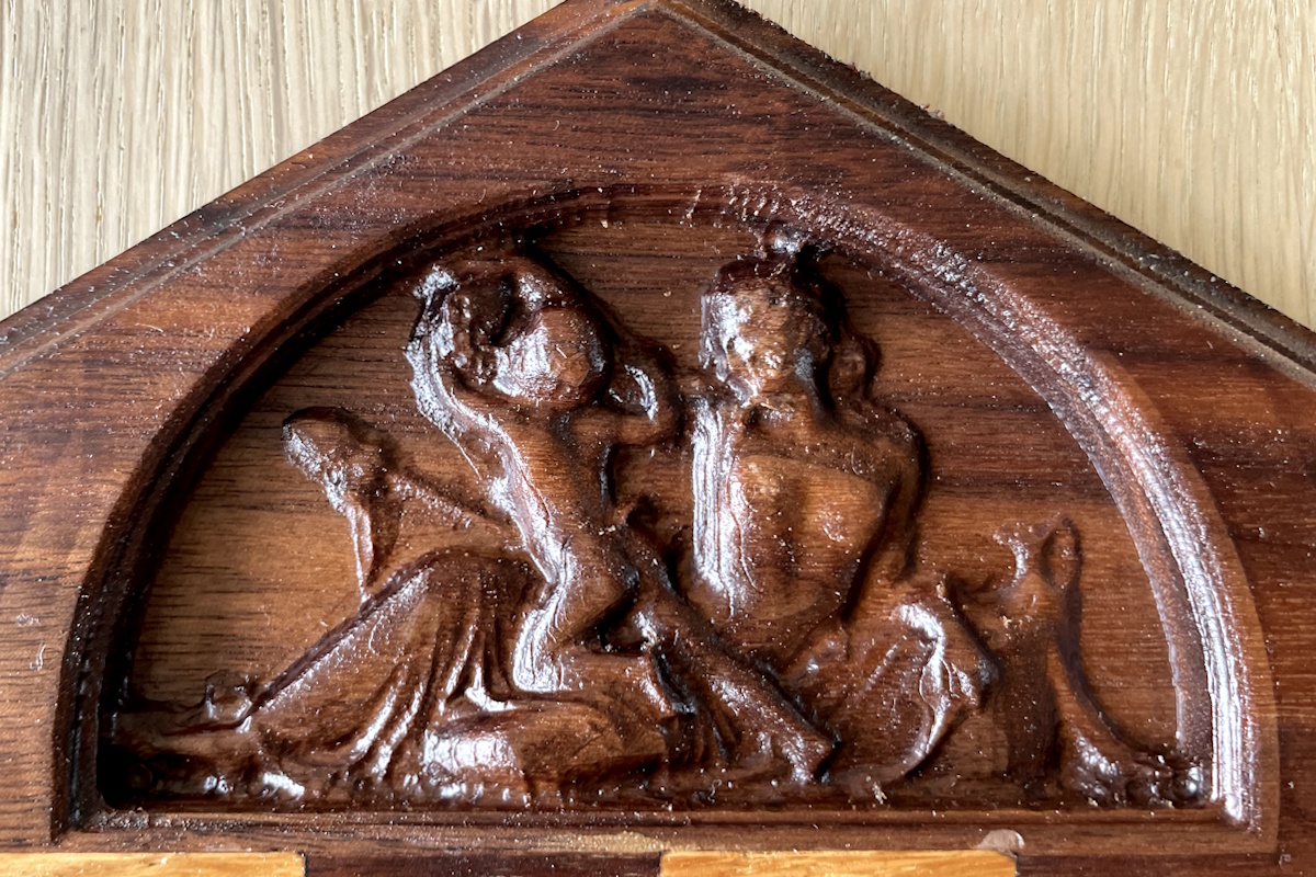 Relief-indgravering i træ, detaljeret dekorativt håndværk med klassisk og elegant design.