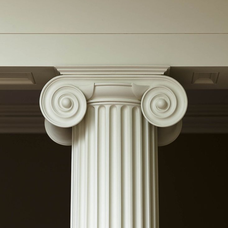 Jonisk søjle med elegante spiralkapitæler, klassisk arkitektonisk design og dekorative detaljer.